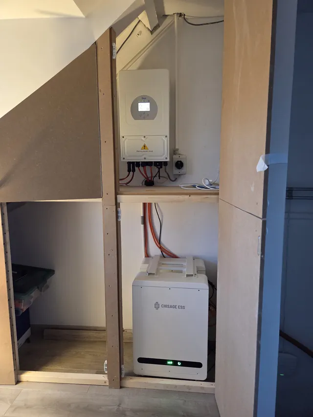 Deye inverter in an under-stair cupboard with timber framing, with a Chisage ESS battery on the floor below.